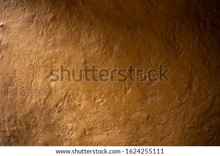 Soil wall texture of clay house and orange light. Mud background, Vintage tone