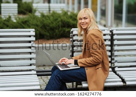 Businesswoman is typing on laptop/ working outside