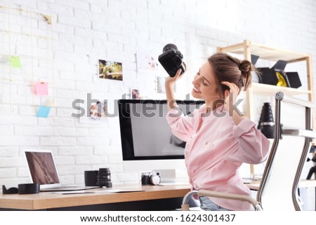 Professional photographer with camera at table in office