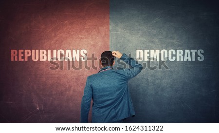 Puzzled businessman and a split wall with Democrats versus Republicans, red vs blue sides. Correct choice, left or right. Difficult decision and doubt concept. Future presidential elections. Royalty-Free Stock Photo #1624311322