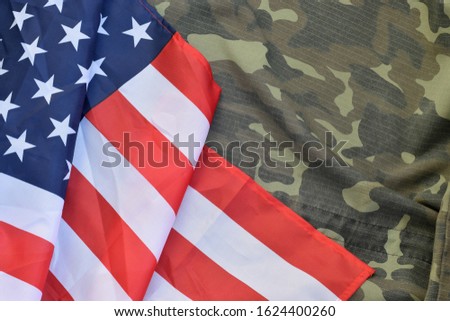 United States of America flag and folded military uniform jacket. Military symbols conceptual background banner for american patriotic holidays