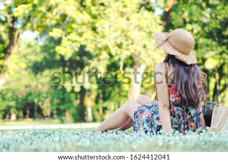 Beautiful young woman relaxing in park. Enjoying the nature.