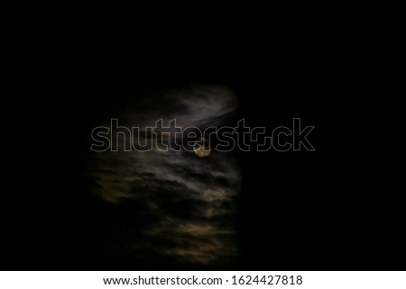 
Full moon behind the clouds on a dark night