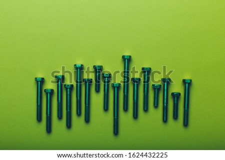 Construction titanium bolts closeup on neon green background. Bright, juicy design greeting card for Father's day or just for man. The concept of repair, work with hands, male occupations, tools.