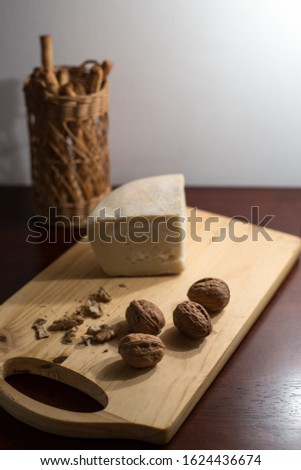 cheese and walnuts on wooden cutting board
