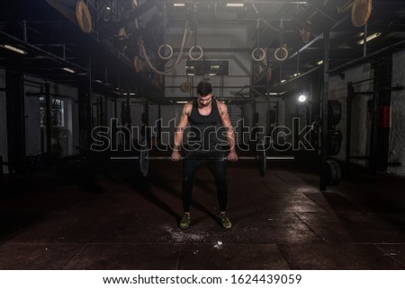 Young strong sweaty fit muscular veteran guy with scars on his skin preparing for heavy cross weightlifting or dead lifting workout training in the gym for rehabilitation