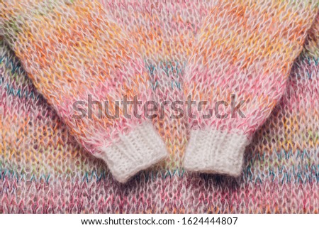 Rainbow knitting wool texture background. A multi-color fluffy sweater made of mohair and woolen threads. A cozy home, hobbies, needlework, handmade winter clothes.