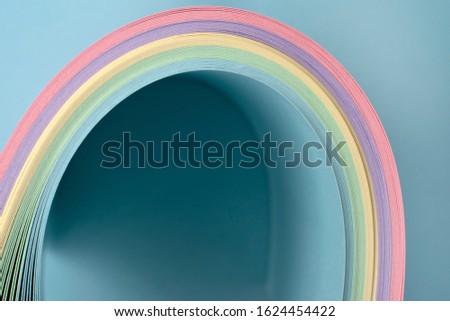Folding pastel paper creating a rainbow. Concept for a card. Artistic design background.