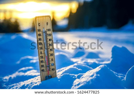 Winter. Thermometer on snow shows low temperatures.