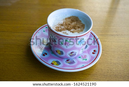 Turkish Salep or Sahlep with cinnamon on wooden table. Hot drink for warming up in winter season. Traditional milky hot drink in Middle East and Arabic culture. Protect from cold. 