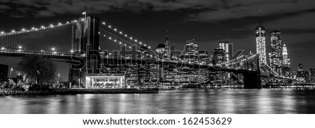 Brooklyn Bridge with Manhattan skyline in the background at night in black and white