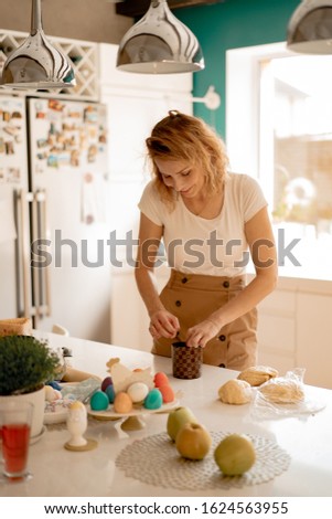 young woman prepares Easter cake with dried fruits and raisins