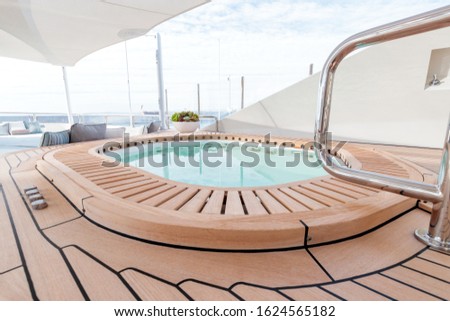 A pool on a yacht with a cloudy sky in the background