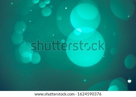 Abstract bokeh lights with green and black background. Beautiful bokeh from water droplets.
