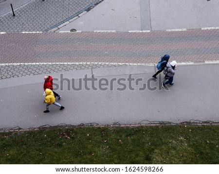 A high angle shot of the people passing through the sidewalk on an ordinary working day