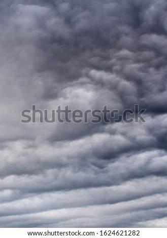 A stormy gray sky is filled with layers of clouds on a winters day