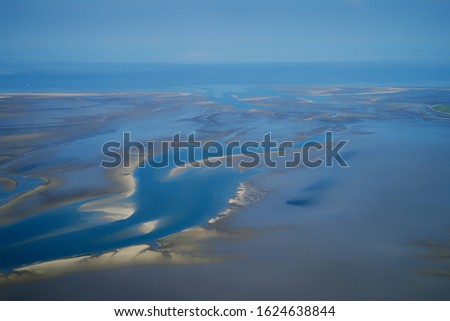 scenic aerial view of tideways and sandbanks in the Lower Saxony Wadden Sea national park at the German North Sea coast during low tide