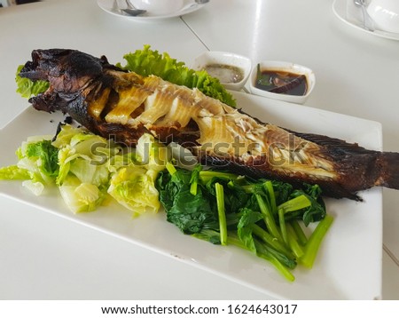 Grilled snakehead fish with boiled vegetables, Local Thai food. Royalty-Free Stock Photo #1624643017
