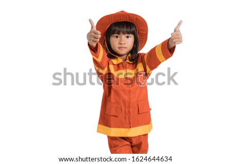 Little girl wearing firefighter uniform with thumbs up hands gesture on white background