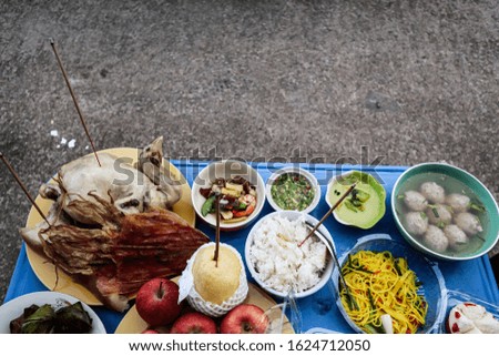 Pictures of food prepared to pay respect to the Chinese New Year include fruits, desserts, rice, pork, chicken, squid, a long tradition in Thailand.