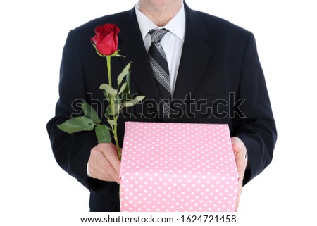 Valentines Day. A man holds a Valentine's Day Rose. Isolated on white. Room for text. Clipping Path. Roses represent love world wide. Valentine's Day is when people give each other gifts of love. 
