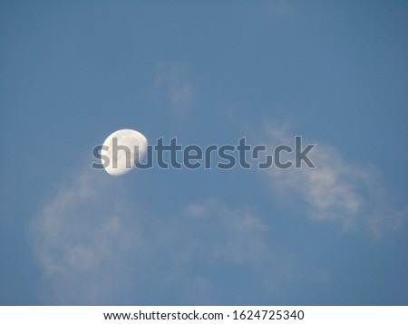 incomplete moon in the blue sky