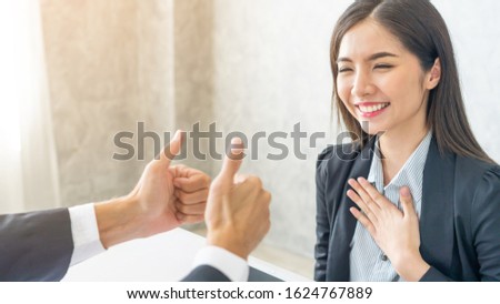 Asian business woman employee with smiling face for her success good job compliments from her boss and given a thumbs up  - business success concept  Royalty-Free Stock Photo #1624767889