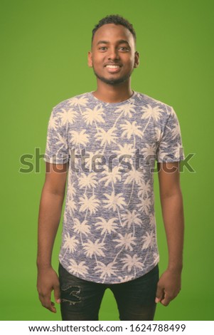 Young handsome African man against green background