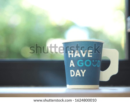 Coffee mugs are made from paper with a message placed by the window in the morning.