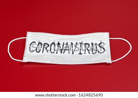 Сoronavirus - COVID-19 - 2019-nCoV, WUHAN virus concept. Surgical mask protective mask with CORONAVIRUS text. Chinese coronavirus COVID-19 outbreak. Red background. Royalty-Free Stock Photo #1624825690