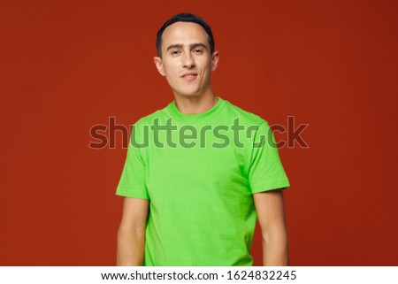 Green shirt red background man cropped view
