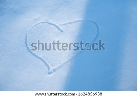 Heart shaped drawing on snow.