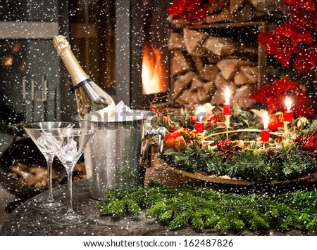 festive home interior decoration for christmas and new year with bottle of champagne and fireplace. candlelight dinner. picture with falling snow effect