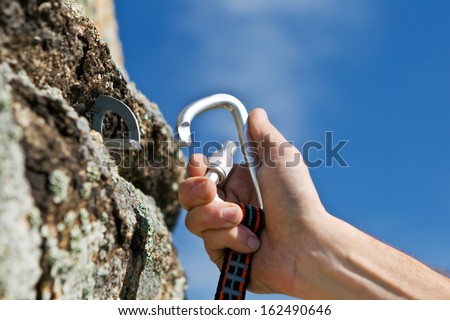 The sportsman hangs up carbine in hook on background blue sky Royalty-Free Stock Photo #162490646