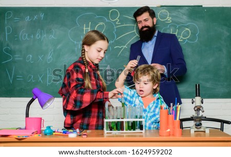 back to school. kids in lab coat learning chemistry in school laboratory. chemistry lab. making experiment in lab or chemical cabinet. happy children teacher. New ideas for medicine.