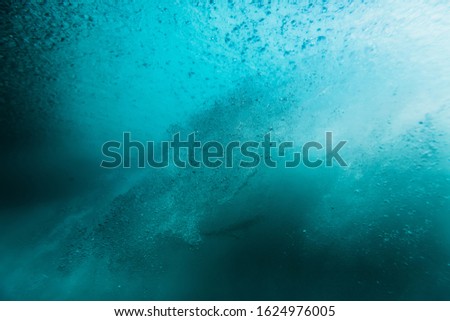 Wave with bubbles underwater. Transparent ocean in underwater
