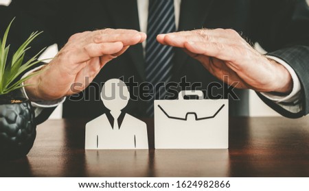 Insurer protecting an employee and a briefcase with his hands Royalty-Free Stock Photo #1624982866