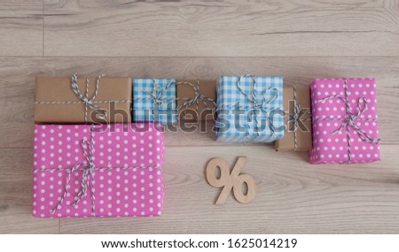 percentage sign and colorful gift box on wooden floor indoors background. Top view