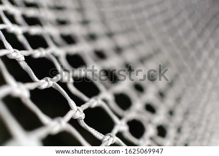 Detail of football goal – white net of ropes. Macro or close-up of a soccer or hockey net – Shallow depth of field. Football concept wallpaper or background. Texture of goal net.