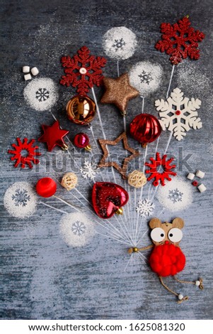 Christmas composition on the theme of the year of the mouse. A toy mouse flies on Christmas balls in the shape of a balloon on a blue background, vertical