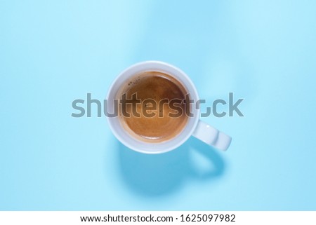 Fresh one cup cappuccino coffee with milk on pastel blue color. Food background. Top view. Flat lay. Minimalism