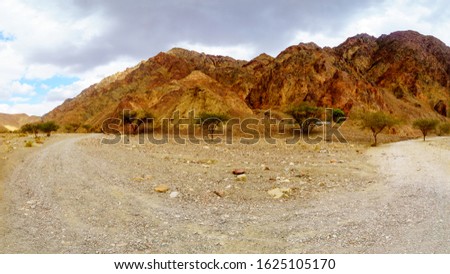 Panoramic view of the Nahal Shlomo (desert valley), with direction sign. Eilat Mountains, southern Israel. Logo in non-commercial (National Nature Reserves Authority)