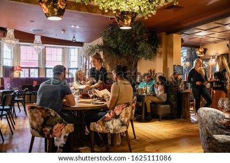 A wide shot of people dining at a restaurant in Newcastle-upon-Tyne. Royalty-Free Stock Photo #1625111086