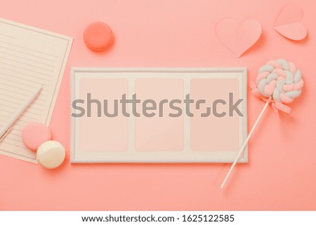 A white sheet of paper for message to loved one, candy with picture frame on pink background. Happy woman's day concept. Mock up
