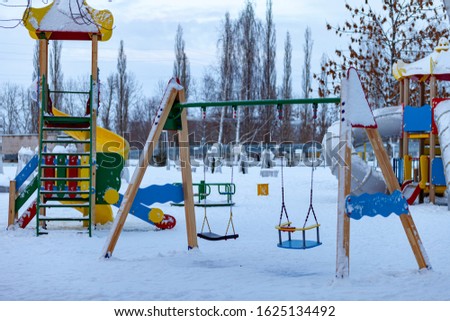 winter city park. Playground for children, slide, swing. Russia