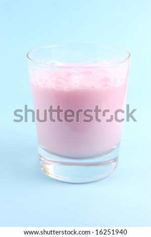 A strawberry flavoured glass of milk isolated against a blue background