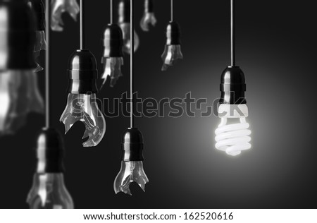 idea concept with broken bulbs and one glowing energy saving bulb
