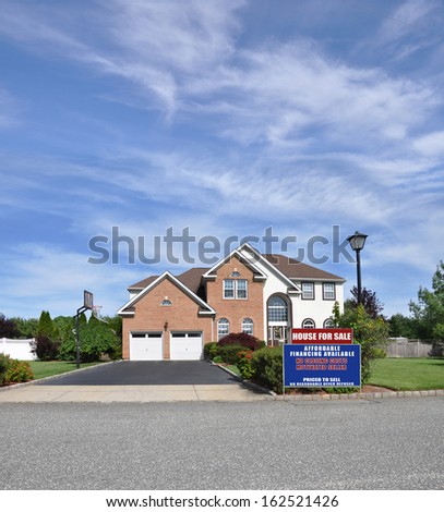 Open House Real Estate Sign Brick Suburban McMansion Home Two Car Garage Residential Neighborhood Street Blue Sky Clouds USA