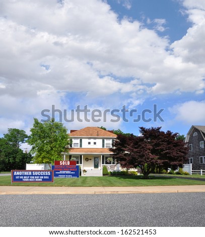 Real Estate Sold For Sale Sign Another Success Let Us Help You Buy Sell Your Next Home on front yard lawn Suburban Home with Japanese Maple Tree Sunny Blue Sky Clouds Residential Neighborhood USA