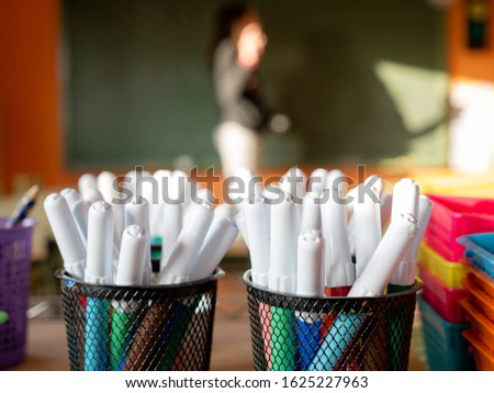 two pen holders with color marker pens, education concept